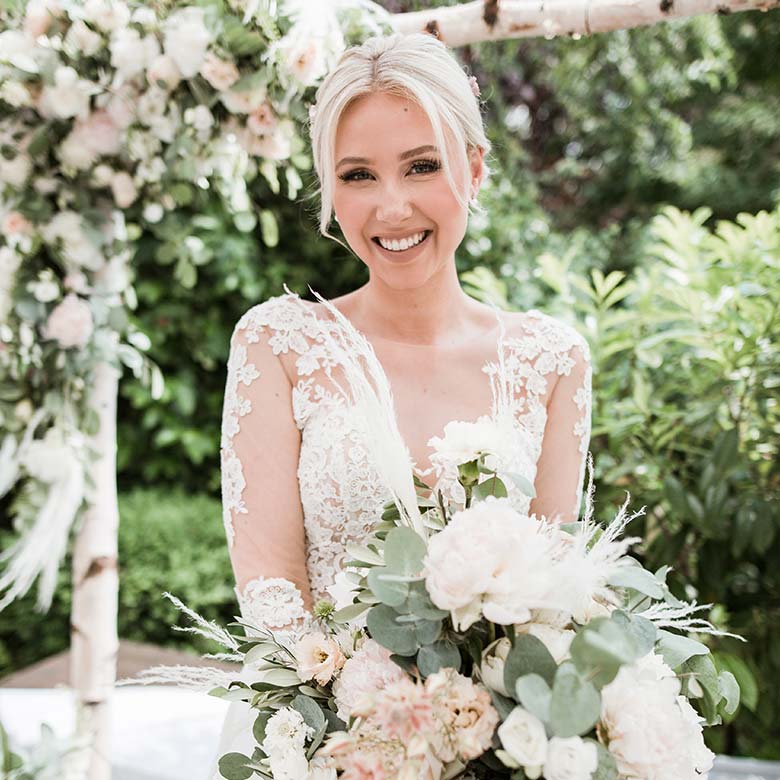 Just Celebrate | Braut lächelnd mit Blumenstrauß